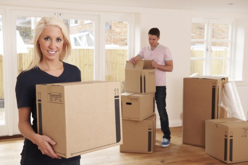 Moving team handling boxes and furniture in Swiss Cottage apartment building