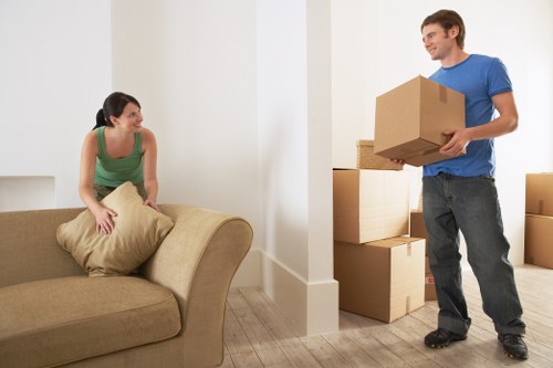 Movers handling boxes and furniture in a Swiss Cottage apartment building